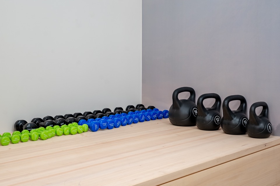 Kurzhanteln und Kettlebells aufgereiht