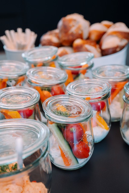 Gemüsegläser und Laugengebäck am Buffet