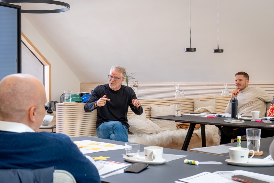 Trainer erklärt gestikulierend in der Seminarrunde