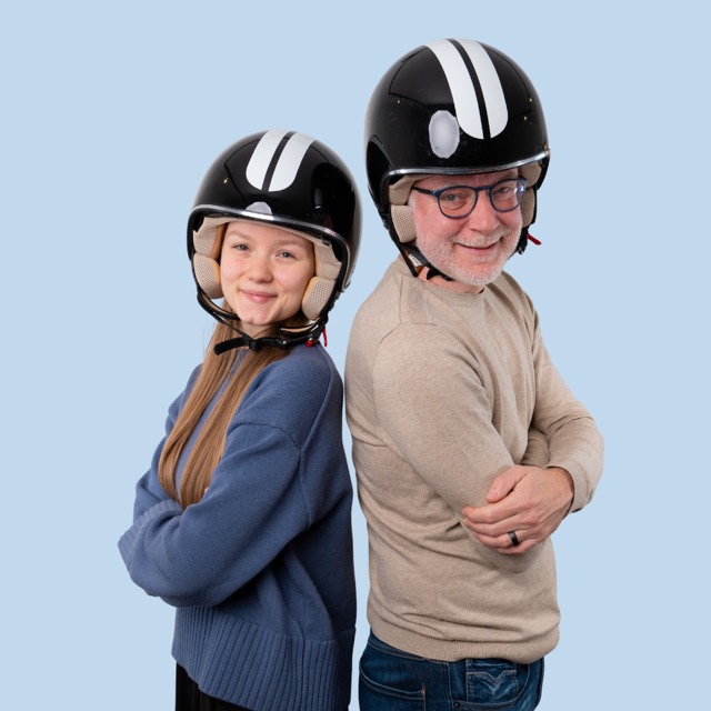 Zwei Personen mit Motorradhelmen Rücken an Rücken
