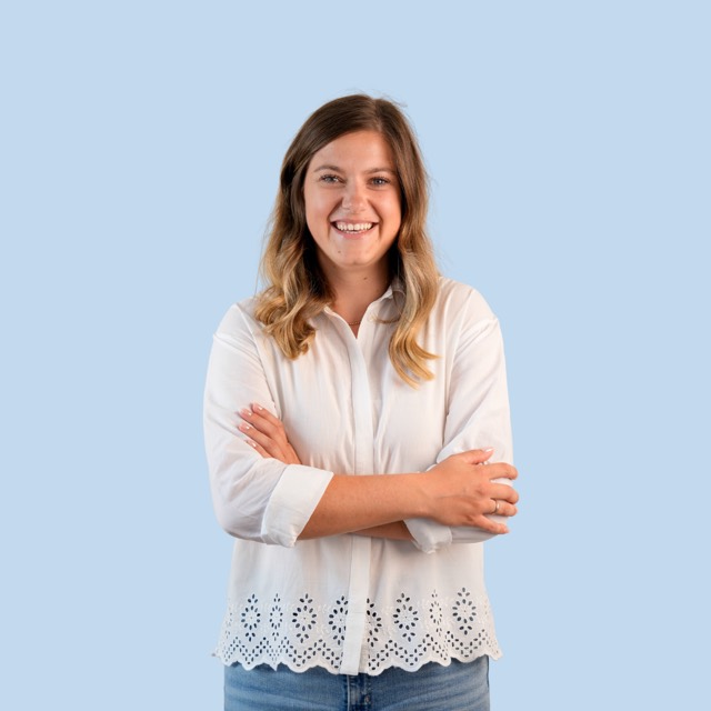 Porträt einer Frau in weißer Bluse vor blauem Hintergrund