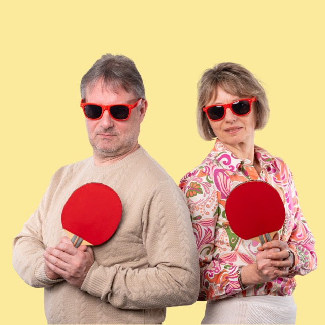 Duo mit Sonnenbrillen und Tischtennisschlägern vor gelbem Hintergrund