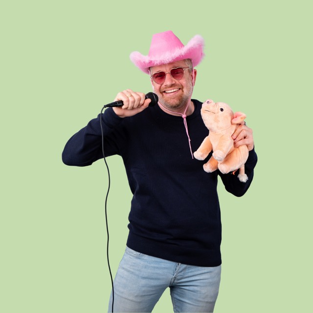 Mann mit rosa Cowboyhut, Mikrofon und Plüschschwein