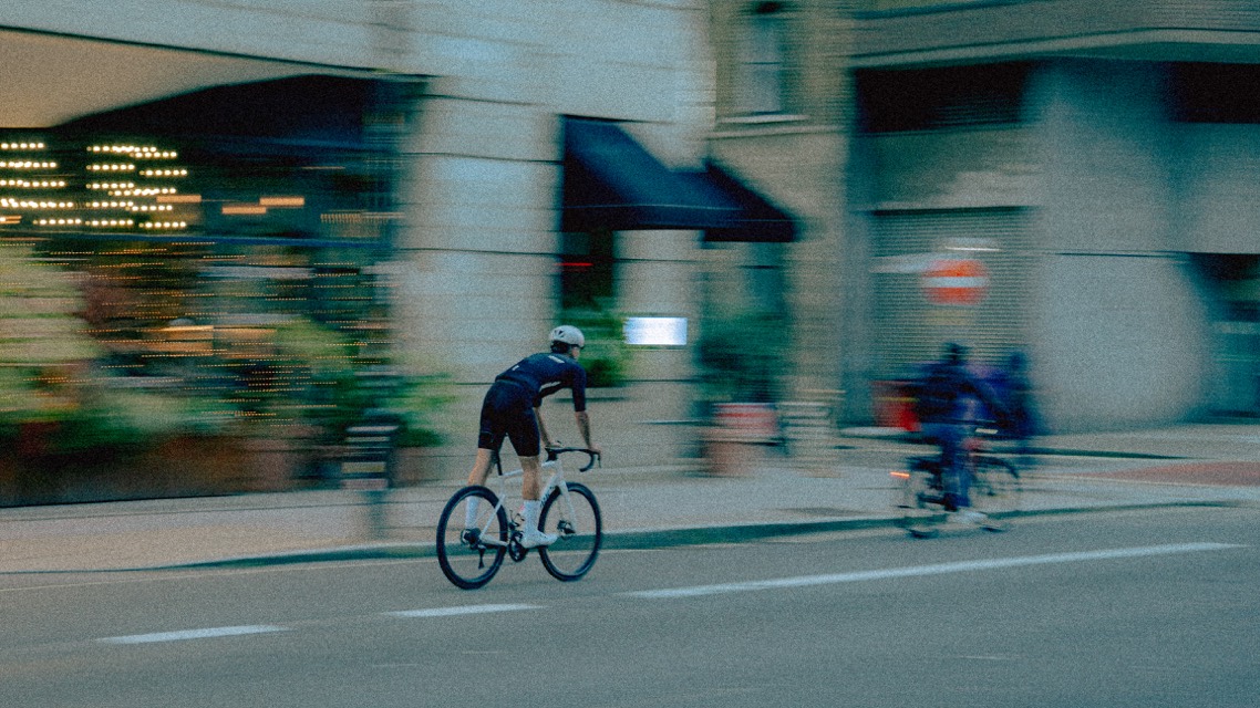 Radfahrer im Mitzieher vor Schaufenstern