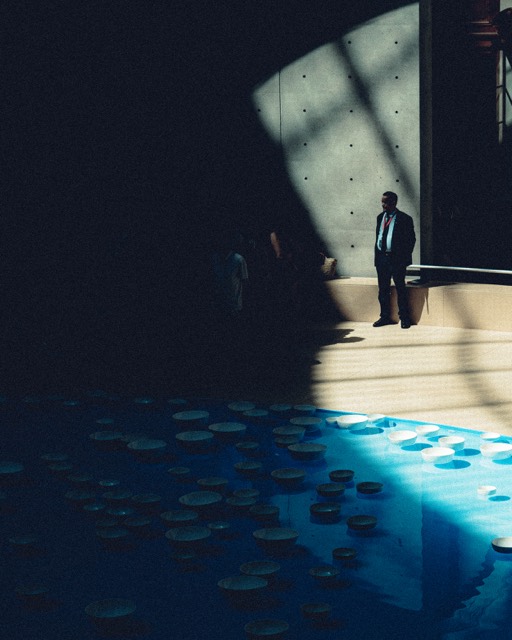 Person im Lichtkegel vor einem Wasserbecken