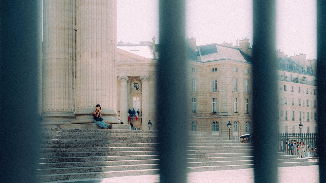 Säulen und Treppe durch ein Gitter gesehen